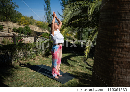 Woman practicing yoga outside on a sunny day 116061883