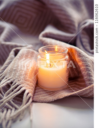 Enjoy the tranquil ambiance of a serene evening with cozy candlelight and a warm blanket fabric 116062610