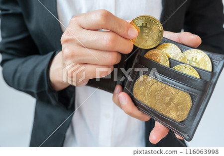 Cropped shot of businessperson collecting golden Bitcoin token in leather wallet. Bitcoin is one of the popular cryptocurrency, a virtual currency or a digital currency. Cropped shot of businessperson collecting golden Bitcoin token in leather wallet. Bitcoin is one of the popular cryptocurrency, a virtual currency or a digital currency. 116063998