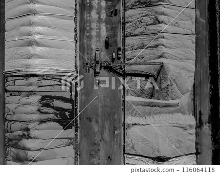 Drone view over grain storage piles being filled and covered Drone view over grain storage piles being filled and covered 116064118