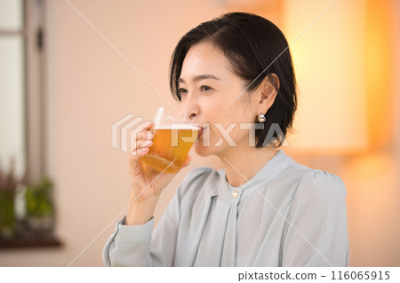 A middle-aged woman drinking beer with relish A middle-aged woman drinking beer with relish 116065915