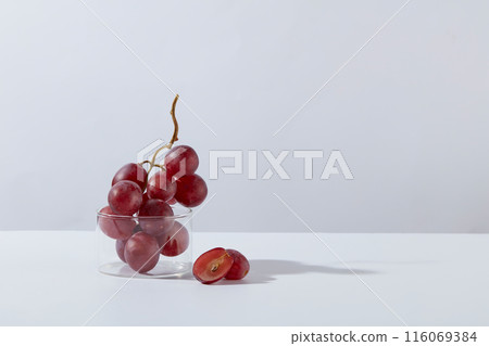 Minimalist style photo with purple grape and laboratory tools on white background. A bunch of grape contained in a glass beaker, placed on the left side, blank right side for adding product or text Minimalist style photo with purple grape and laboratory tools on white background. A bunch of grape contained in a glass beaker, placed on the left side, blank right side for adding product or text 116069384