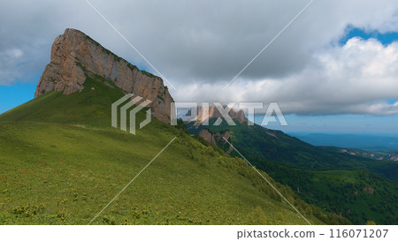 A spectacular view of the North Caucasus mountain range in southwestern Russia, showing the natural beauty of the rocky peaks under rain clouds. 116071207