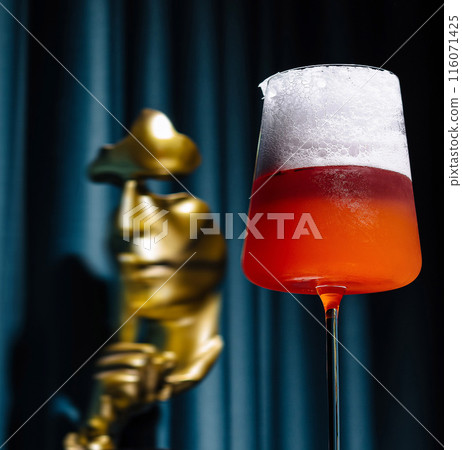 Elegant cocktail by statue with dramatic lighting Elegant cocktail by statue with dramatic lighting 116071425