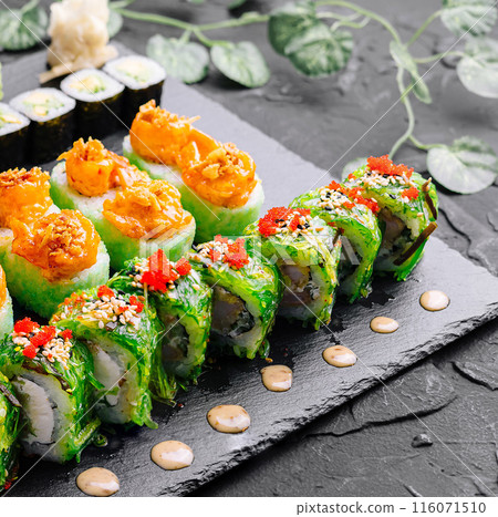 Exquisite sushi platter on dark slate background 116071510