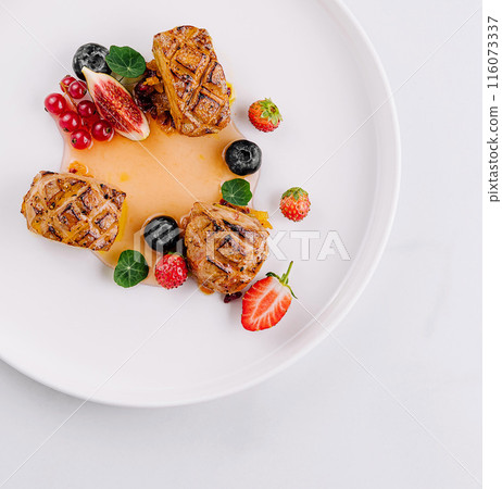 Elegant gourmet meat with berries on white plate 116073337