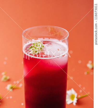Refreshing berry smoothie with floral garnish 116073811