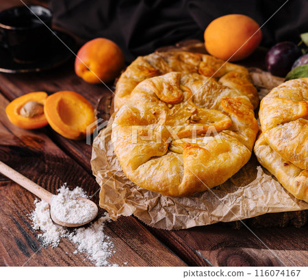 Rustic homemade fruit galettes on wooden table 116074167