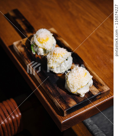 Gourmet sushi rolls on wooden platter 116074227