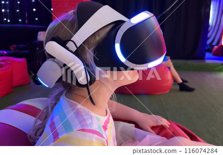 The beautiful gearl wearing VR headset playing in virtual reality. Concept high technology digital device The beautiful gearl wearing VR headset playing in virtual reality. Concept high technology digital device 116074284