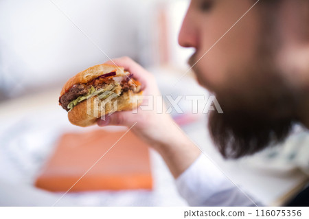 Businessman having quick lunch, fastfood meal in startup company office. Working in co-working space. 116075356