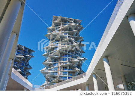 Modern residential building with geometric design against clear blue sky. City architecture with protruding triangular elements against clear blue sky 116075392