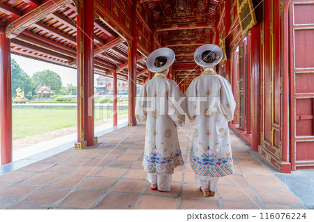 國慶日,一名身著正裝的女子走在順化皇宮的紅色走廊裡。 國慶日,一名身著正裝的女子走在順化皇宮的紅色走廊裡。 116076224