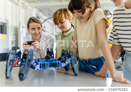 Children learning robotics in Elementary school. Young students programming, building robot in after school robotics club. Field trip to real robotics laboratory. Children learning robotics in Elementary school. Young students programming, building robot in after school robotics club. Field trip to real robotics laboratory. 116076362