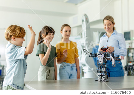 Children learning robotics in Elementary school. Young students building robot in after school robotics club. Field trip to real robotics laboratory. 116076460