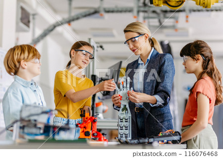 Children learning robotics in Elementary school. Young students building robot in after school robotics club. Field trip to real robotics laboratory. 116076468
