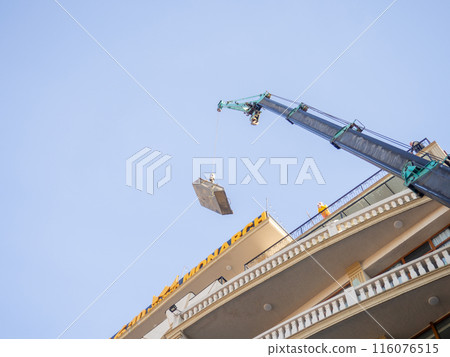 The crane lifts the load onto the roof. Vessel for loading building materials. The crane lifts the load onto the roof. Vessel for loading building materials. 116076515