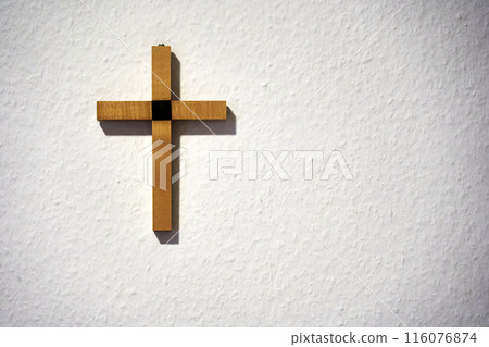 Wooden cross on a white wall 116076874