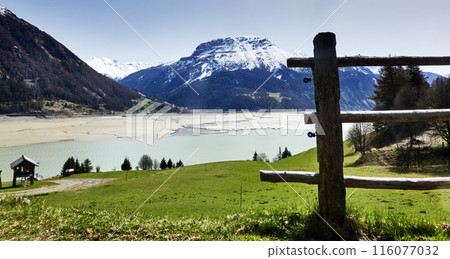 View of the snow-covered peaks of the Alps behind the empty Reschen reservoir View of the snow-covered peaks of the Alps behind the empty Reschen reservoir 116077032