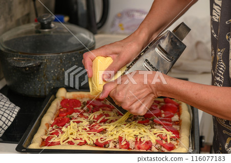 woman prepares pizza with cheese, tomatoes and chicken ham, woman rubs cheese 4 woman prepares pizza with cheese, tomatoes and chicken ham, woman rubs cheese 4 116077183