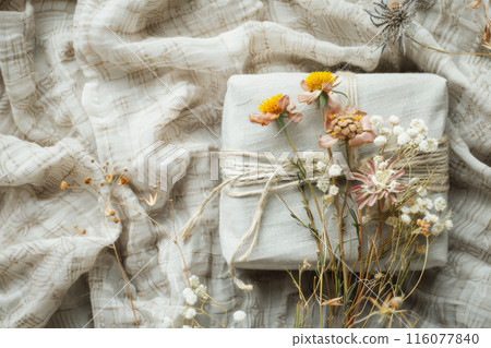 Sustainable gifting. Present wrapped in fabric, adorned with twine and dried flowers Sustainable gifting. Present wrapped in fabric, adorned with twine and dried flowers 116077840