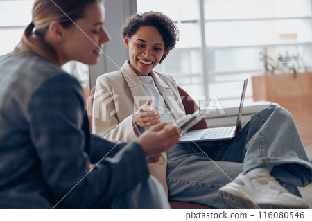 Woman office worker discussing new project with colleague during working day in coworking Woman office worker discussing new project with colleague during working day in coworking 116080546