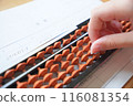 Hands using an abacus 116081354