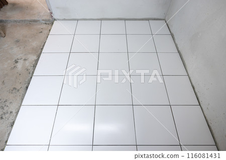 Tile floor under construction in room. 116081431