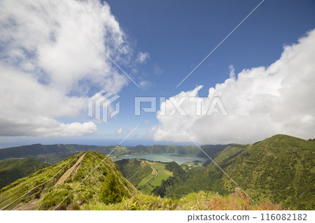 A mountain top with a lake in the distance A mountain top with a lake in the distance 116082182