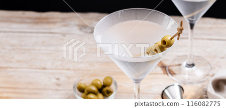 Vodka martini cocktail with vodka and vermouth and green olives on wooden table 116082775