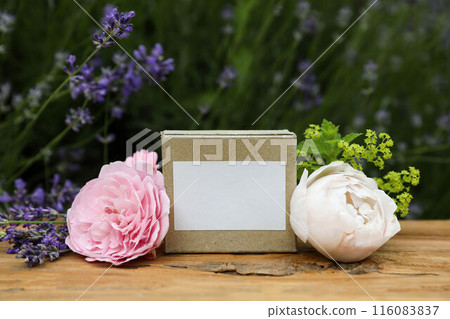 Paper package box. Blank label mockup for soap, facial cream. Rustic wooden table. Lavender herb, roses and alchemilla flowers. Blurred floral background. Skin product mockup scene. Cosmetic product. Paper package box. Blank label mockup for soap, facial cream. Rustic wooden table. Lavender herb, roses and alchemilla flowers. Blurred floral background. Skin product mockup scene. Cosmetic product. 116083837