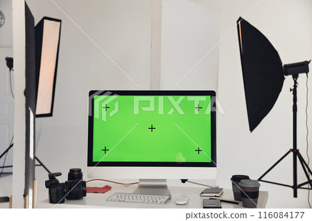 Minimal background image of computer with chroma key green screen on workplace table in photo studio with professional lighting equipment, copy space Minimal background image of computer with chroma key green screen on workplace table in photo studio with professional lighting equipment, copy space 116084177