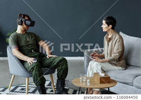 Minimal portrait of army veteran using VR technology in mental health session with female therapist copy space 116084450