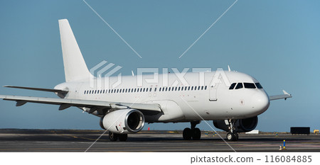 White plane to runway for take off, airplane taxiing for take off. White passenger jet plane taxiing along the runway in the airport 116084885