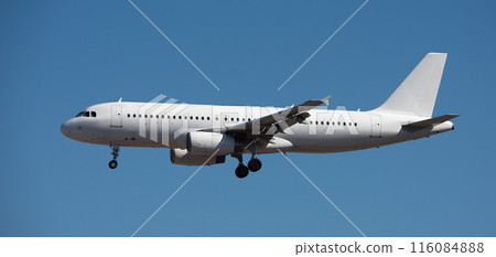 The plane lands.Airplane, passengers flying in the blue sky, preparing to land at the airport The plane lands.Airplane, passengers flying in the blue sky, preparing to land at the airport 116084888