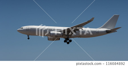 The plane lands.Airplane, passengers flying in the blue sky, preparing to land at the airport The plane lands.Airplane, passengers flying in the blue sky, preparing to land at the airport 116084892