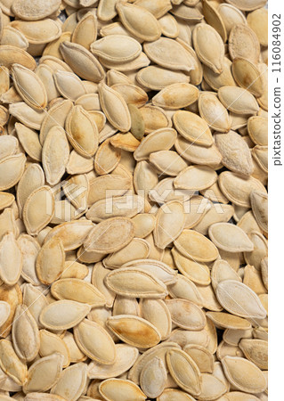 Close-up of unpeeled pumpkin seeds from above. 116084902
