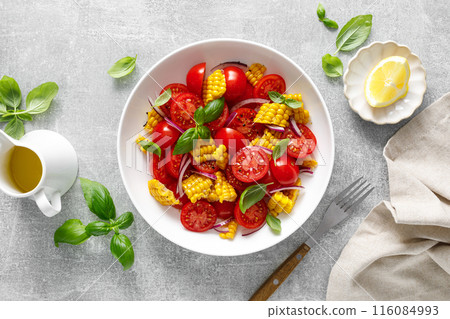 Tomato and corn salad with fresh basil, onion, dressed with olive oil. Mexican food, tomato corn salad Esquites, top view 116084993
