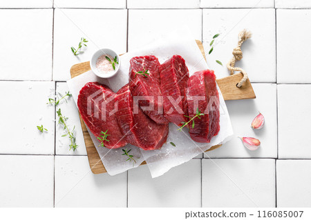 Beef. Raw beef tenderloin meat, beef steaks with ingredients for cooking. Top view Beef. Raw beef tenderloin meat, beef steaks with ingredients for cooking. Top view 116085007