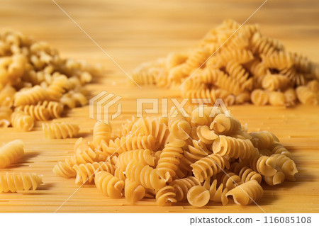 Heaps of raw fusilli pasta close-up. Italian raw pasta mockup Heaps of raw fusilli pasta close-up. Italian raw pasta mockup 116085108