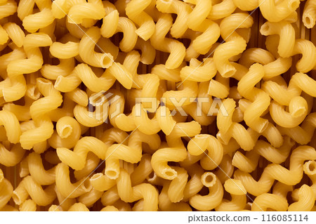 A pile of raw pasta close-up. Italian pasta, pasta cones texture, top view A pile of raw pasta close-up. Italian pasta, pasta cones texture, top view 116085114