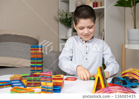 A six-year-old boy plays with a magnetic construction set. Toys for children to develop imagination. A six-year-old boy plays with a magnetic construction set. Toys for children to develop imagination. 116085435
