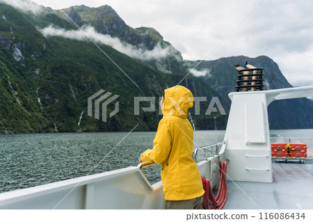 Asian woman enjoying the view of Milford Sound during ferry cruise on vacation at New Zealand 116086434