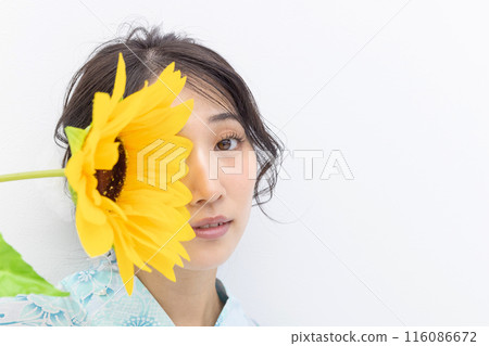 身穿浴衣的年輕女子拿著向日葵,白色背景 身穿浴衣的年輕女子拿著向日葵,白色背景 116086672