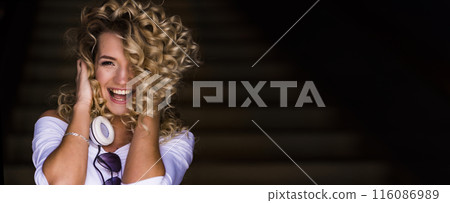 Blond woman listens to music with headphones. Blond woman listens to music with headphones. 116086989