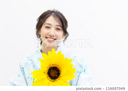 穿著浴衣的年輕女子拿著向日葵,白色背景 穿著浴衣的年輕女子拿著向日葵,白色背景 116087049