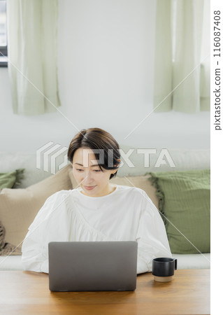 中年婦女在客廳看電腦 中年婦女在客廳看電腦 116087408