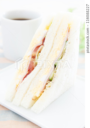 A delicious ham, egg, and vegetable sandwich and hot coffee for breakfast A delicious ham, egg, and vegetable sandwich and hot coffee for breakfast 116088227