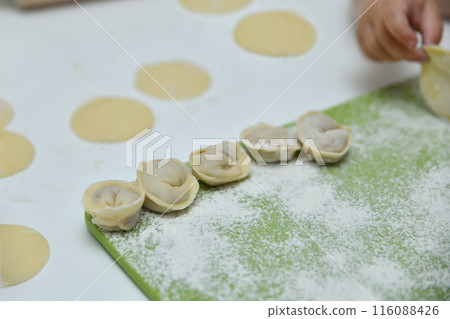 A child's hand making Russian dumplings A child's hand making Russian dumplings 116088426