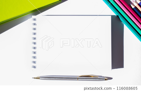 Template. Top view of a White Sheet of notepad with entry field on white background with pencils, pen and folder. Bright image. Business Concept. Education and development 116088605